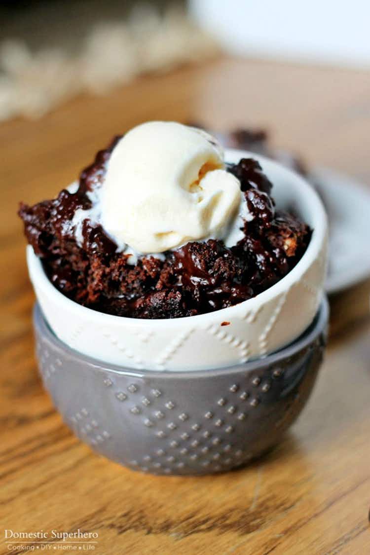 A bowl of chocolate cake topped with vanilla ice cream