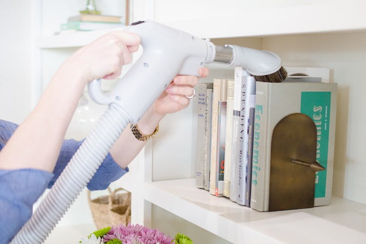 Remove dust from the tops of books with the soft brush attachment on your vacuum