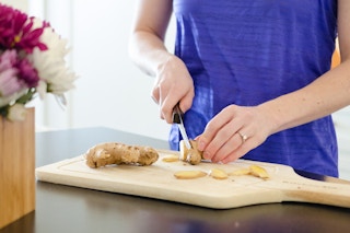 person cutting up ginger root