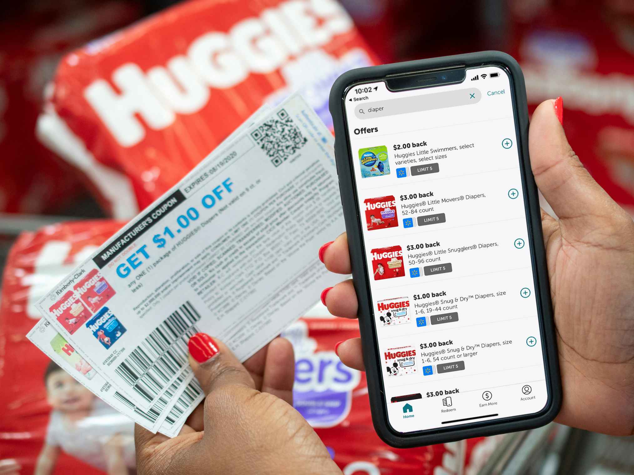 Ibotta app on a cell phone next to coupons and Huggies diapers.