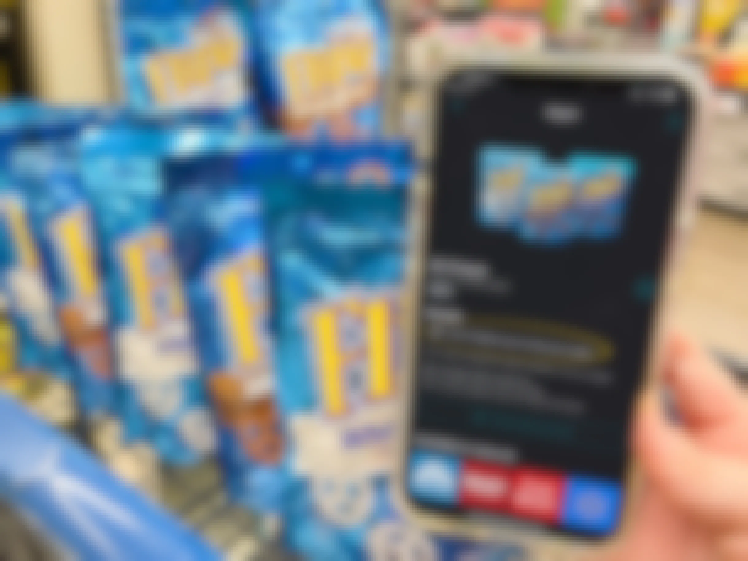 Ibotta app on a cell phone next to a cart filled with flipz