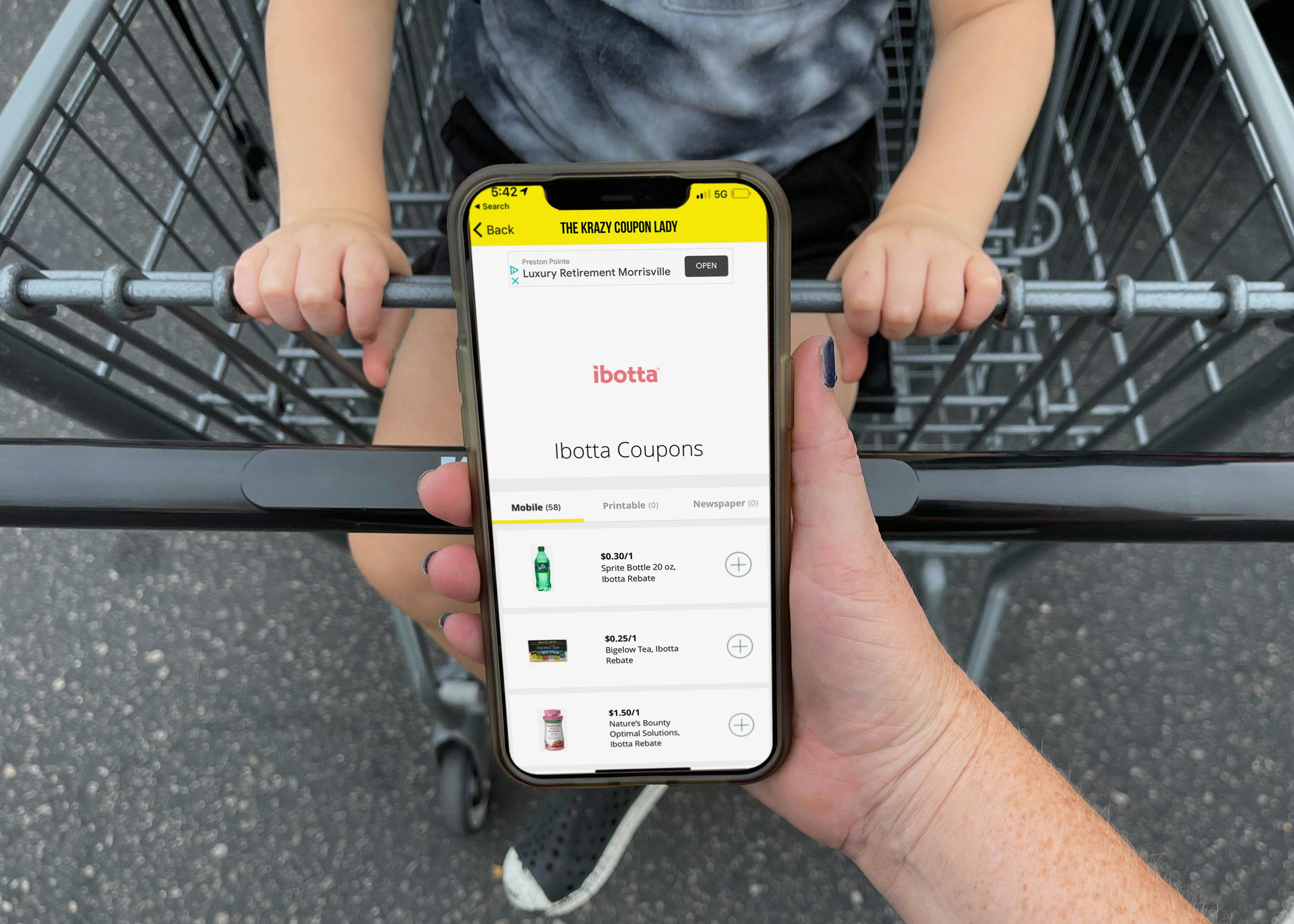 ibotta app being held in front of cart with child