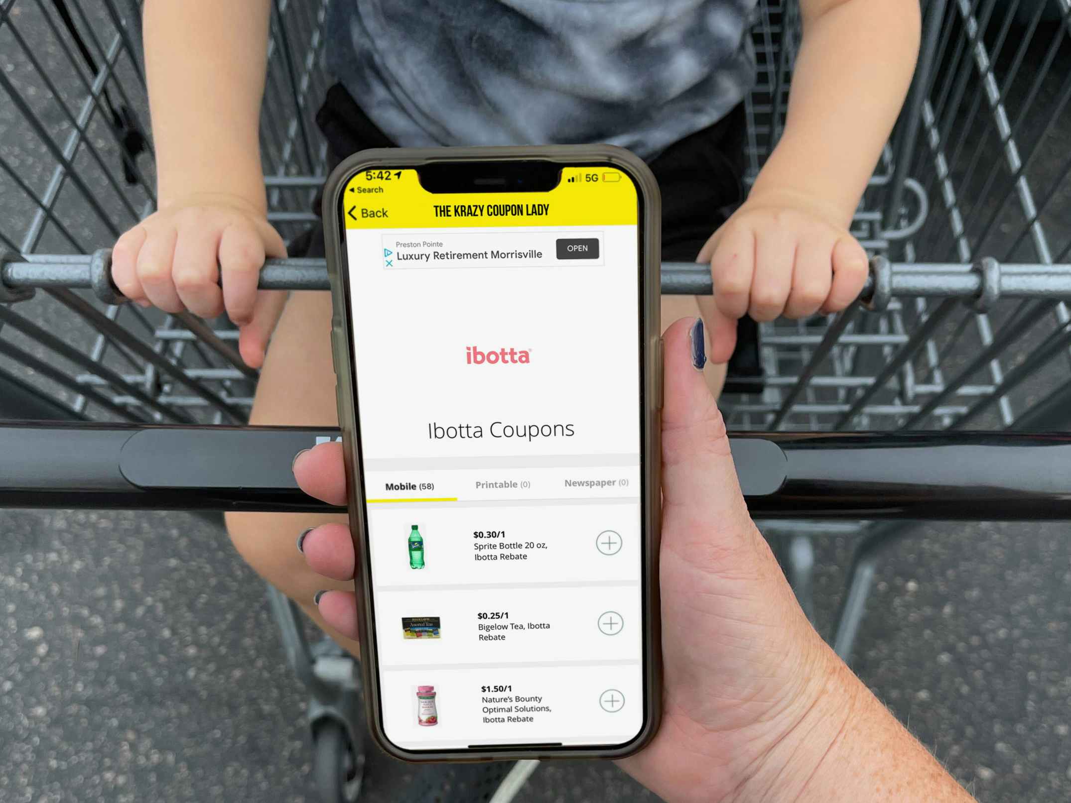 ibotta app being held in front of cart with child