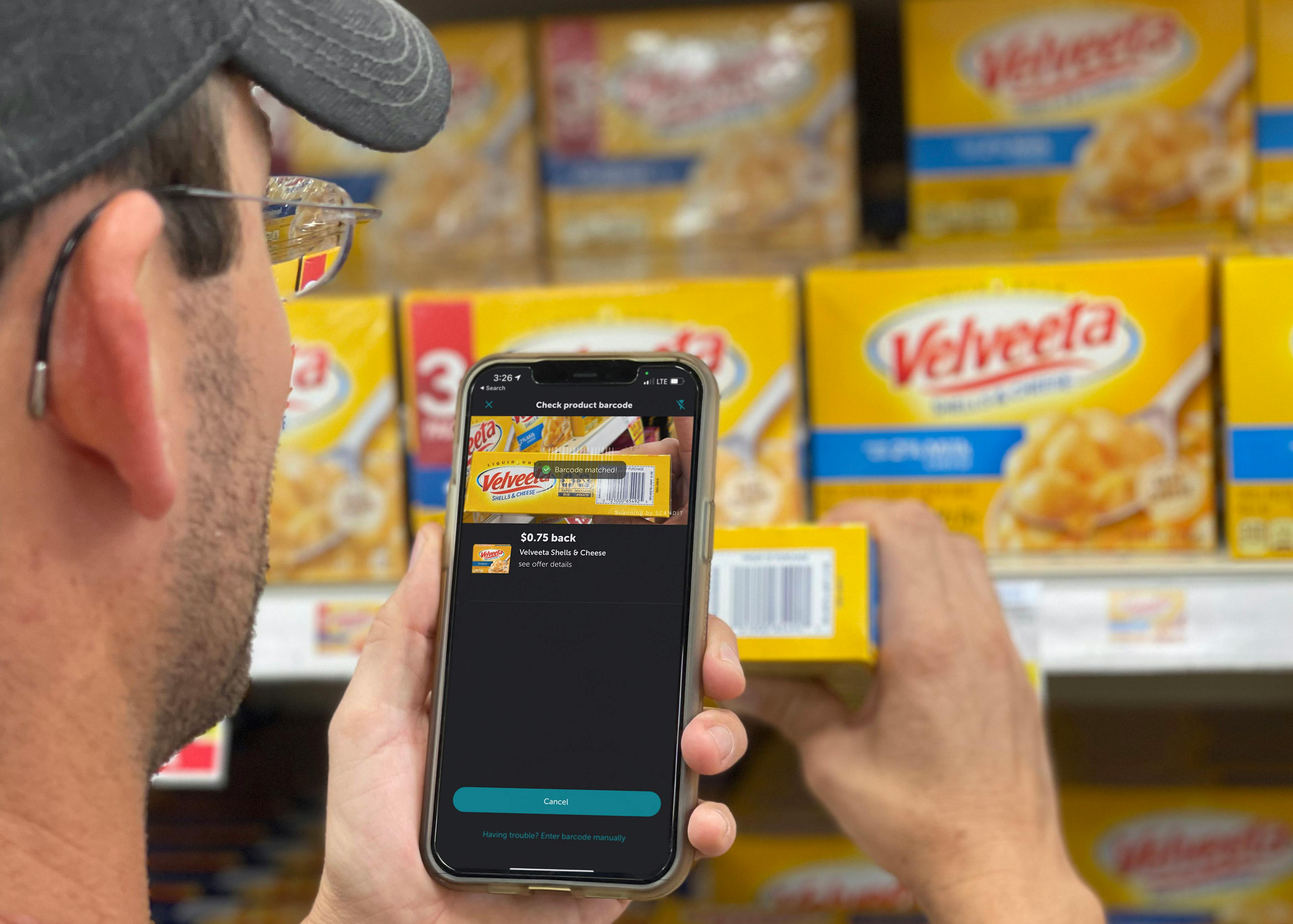 man using cellphone to scan velvetta shells with ibotta app