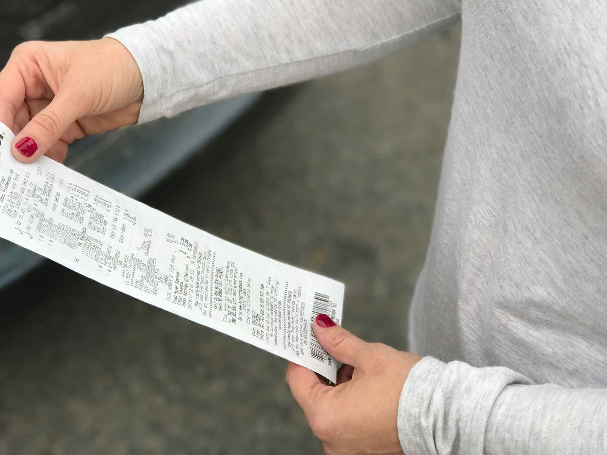 Someone looking at their receipt outside the grocery store