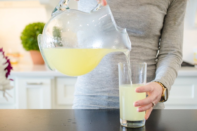 person pouring drink into glass