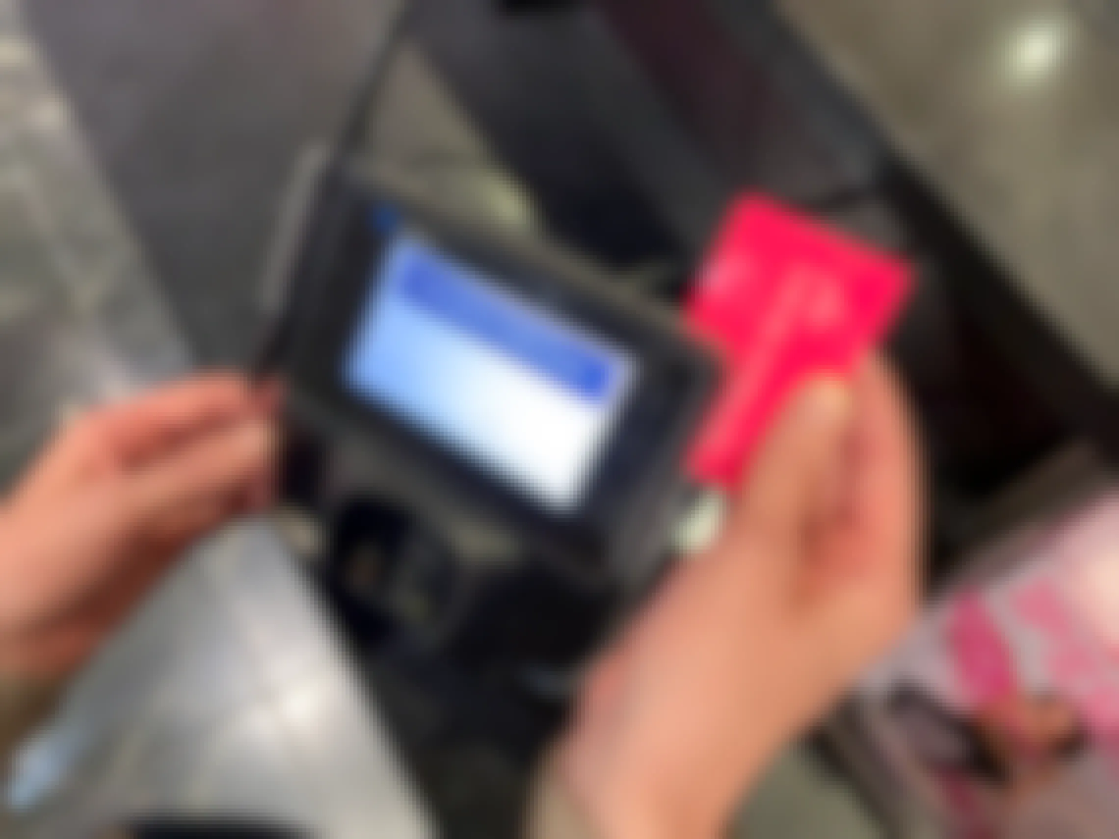 A woman sliding a Victoria's Secret Angel credit card through the credit card reader.