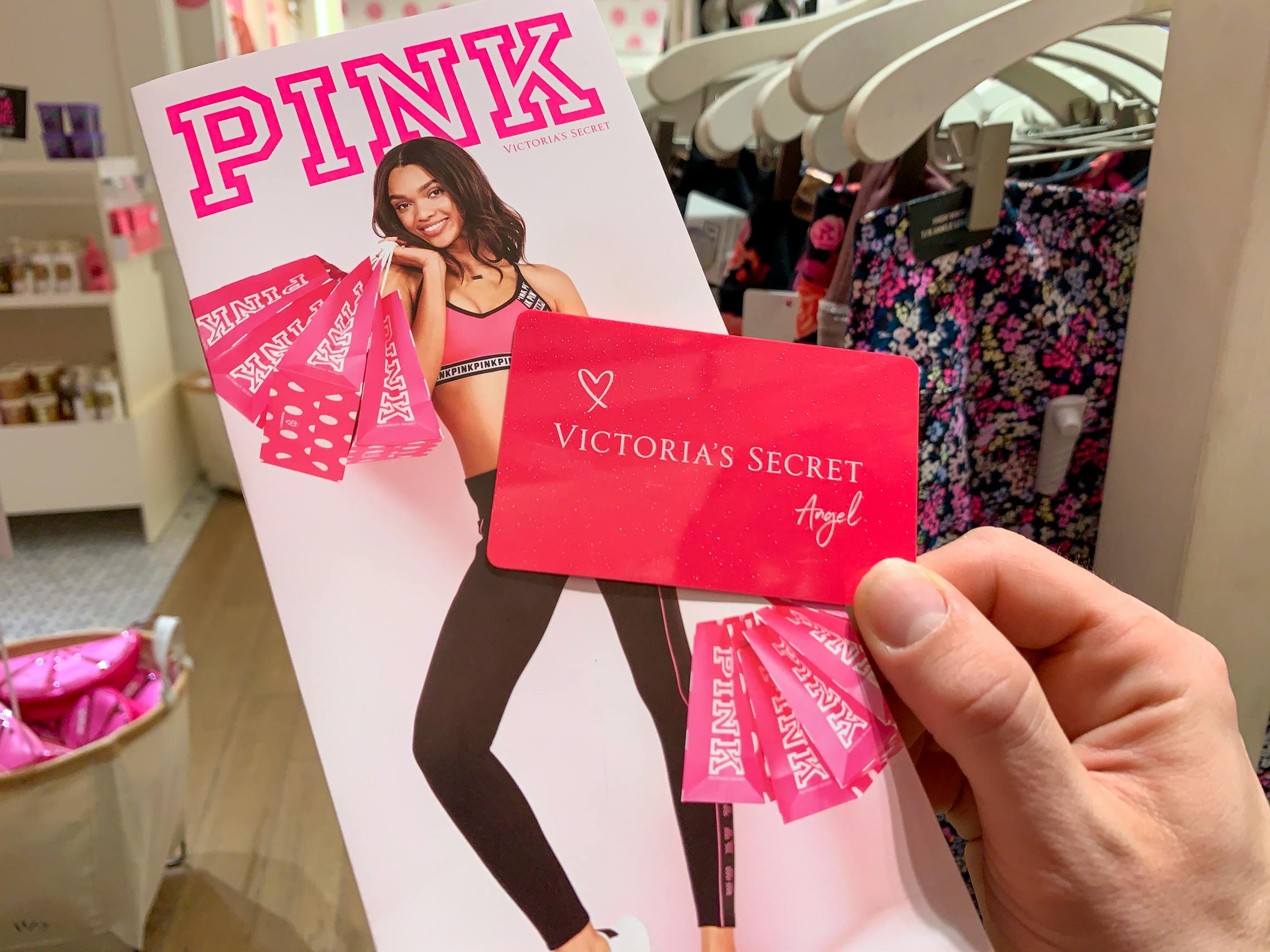 A Victoria's Secret credit card held in front of a Pink pamphlet used for registering for a card.