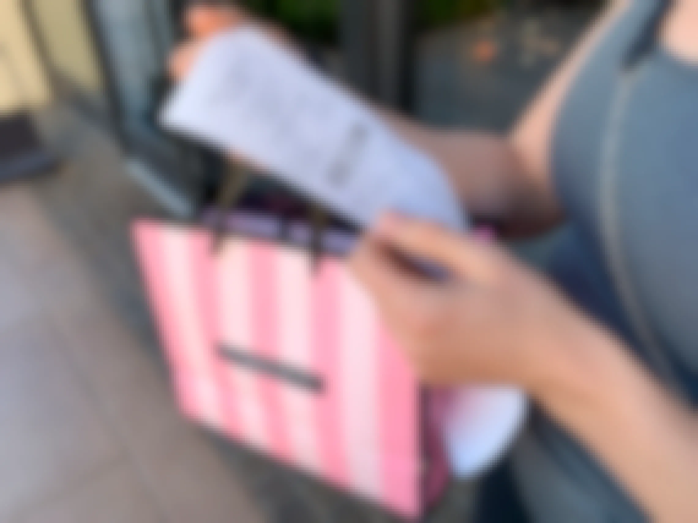 Woman looking at a Victoria's Secret receipt with shopping bag in hand.