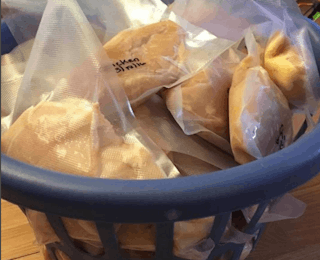 Laundry basket full of vacuum-packed chicken breasts.
