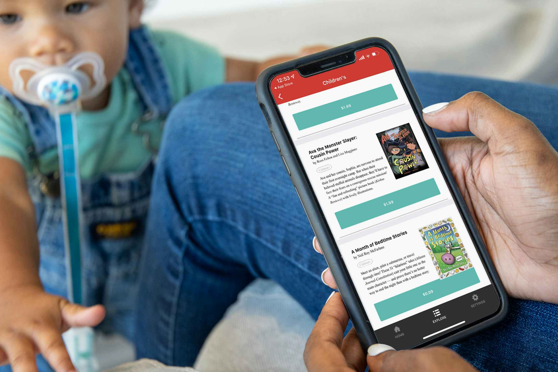 A woman holding a Bookbub app with children's books on the screen. A toddler is in the background.