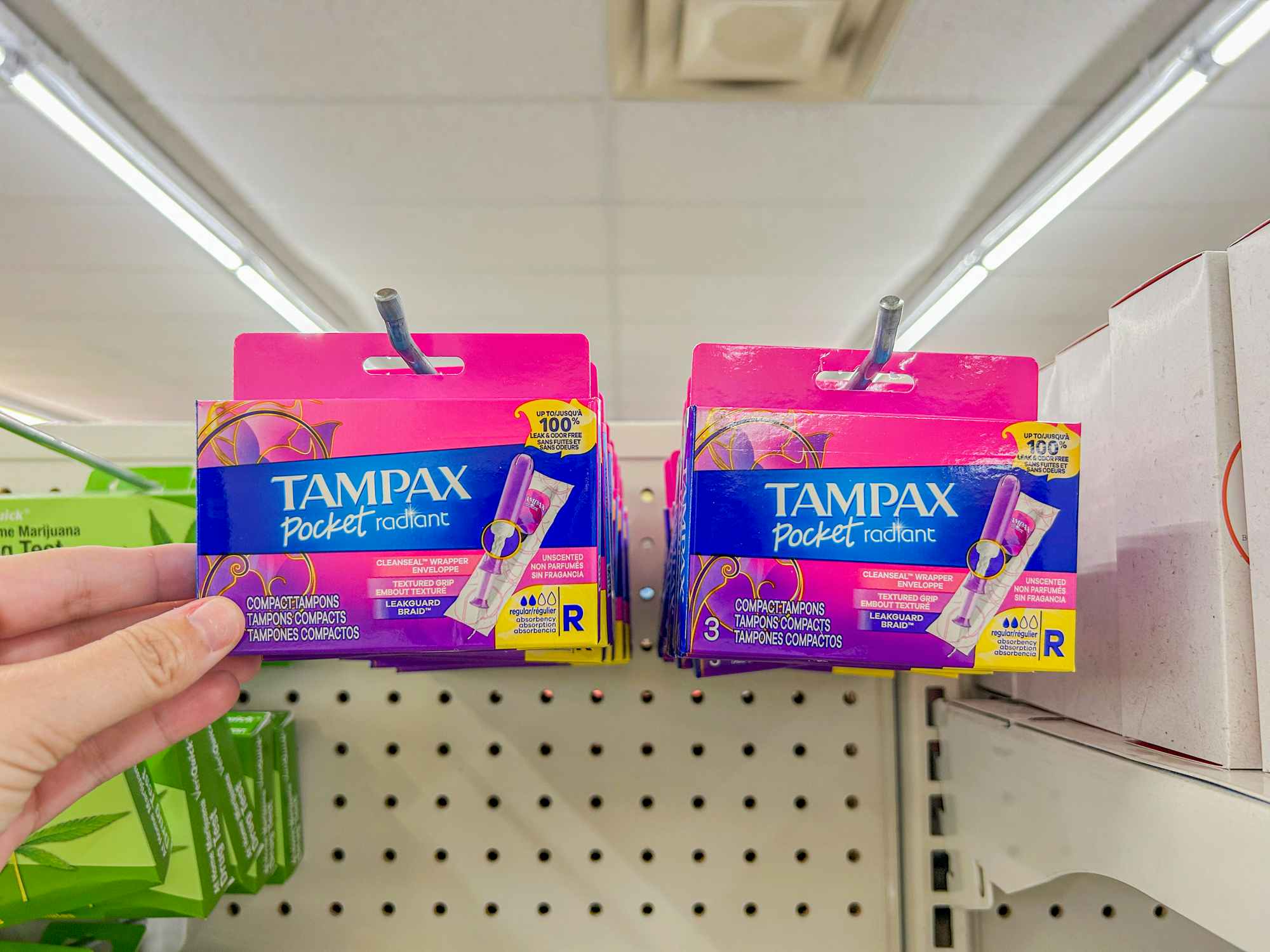 a person holding up tampax tampons in a dollar tree