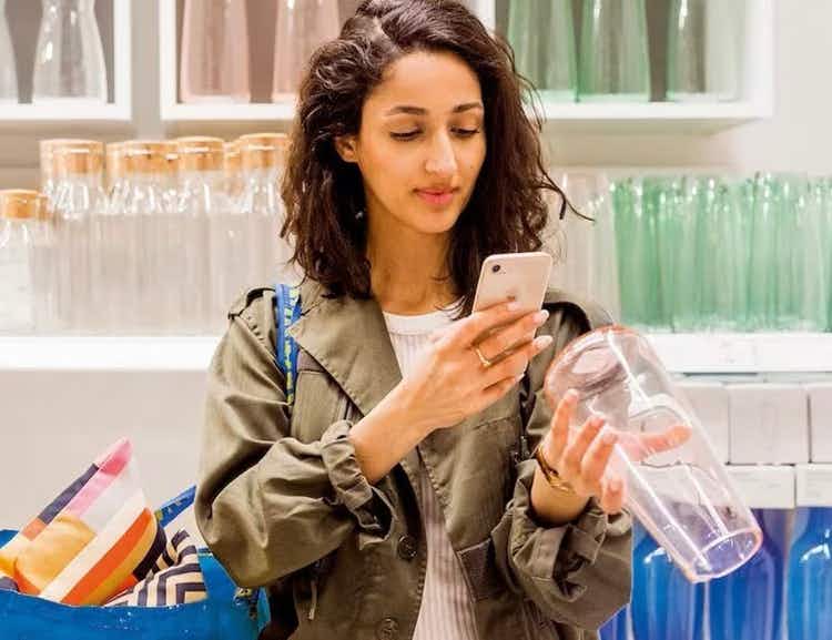 person shopping in ikea and taking a photo of a product with the mobile app