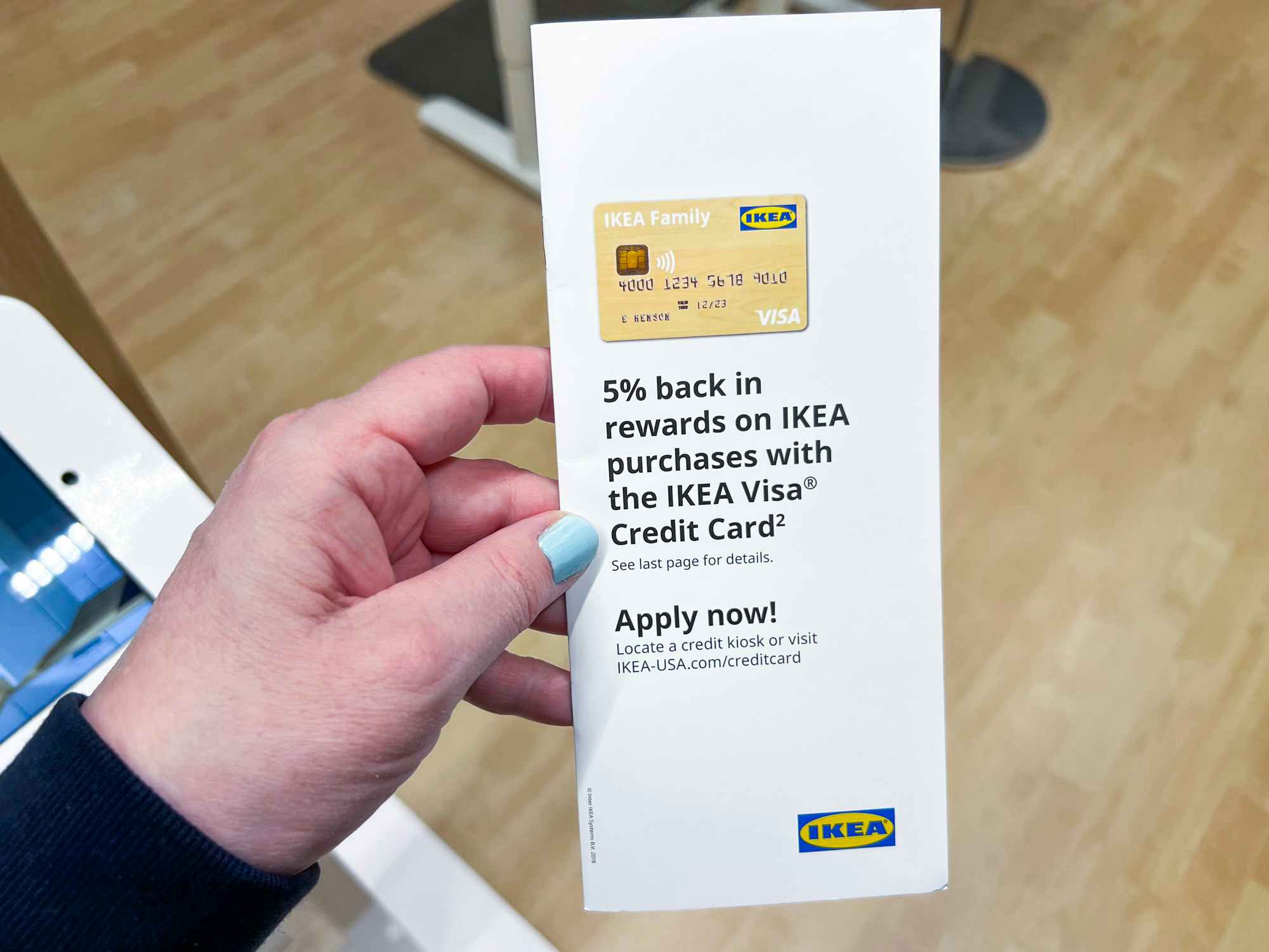 someone holding a brochure for the Ikea Visa Credit Card
