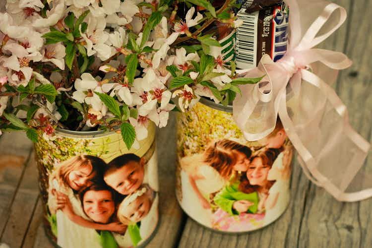 Upcycled tin cans covered with photos and filled with flowers and candy.