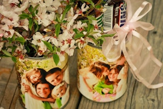 Upcycled tin cans covered with photos and filled with flowers and candy.
