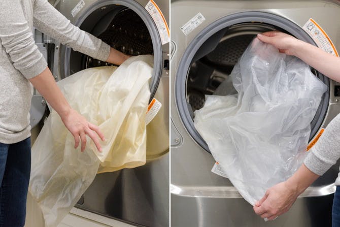 Somene putting a dirty shower curtain liner into a washing machine and removing a clean one.