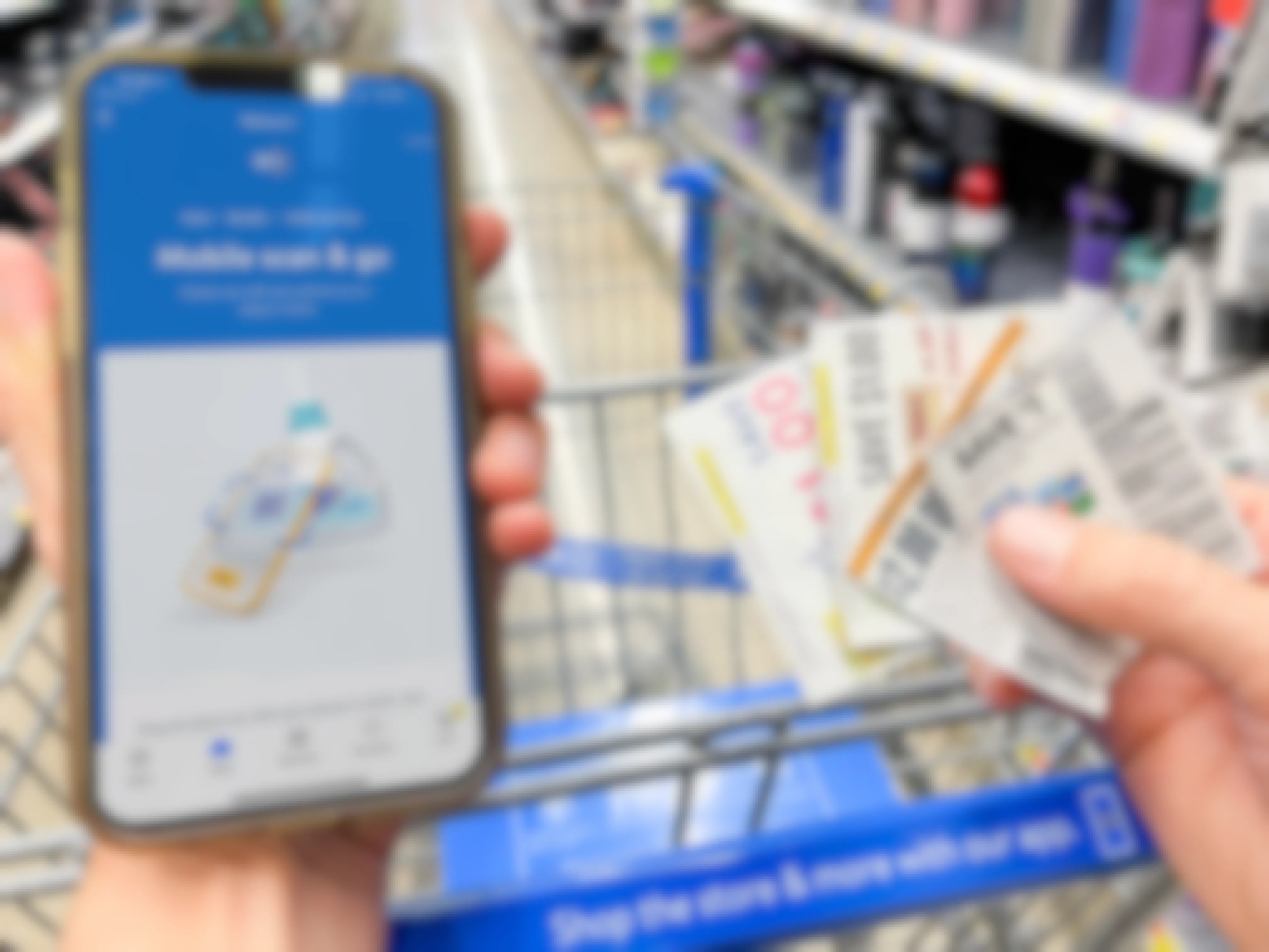 walmart app on cellphone in store by cart with other hand holding coupons