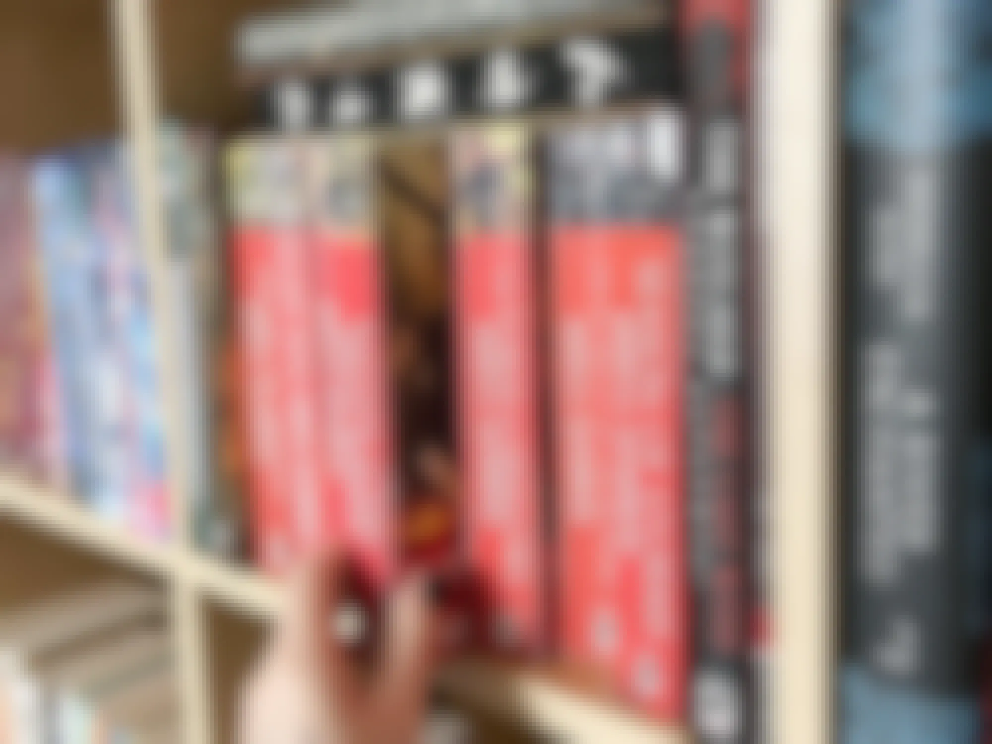 a person reaching for a book on a book shelf