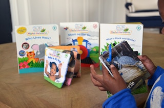 Small boy looking at board books.