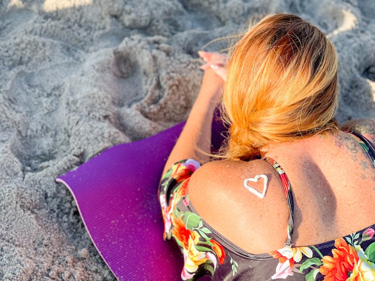 a sunscreen heart on a woman at the beach