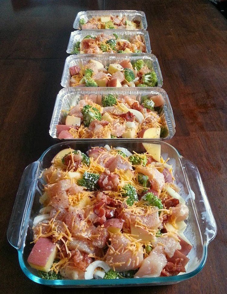 Several baking dishes lined up with chicken, potatoes, broccoli and cheese casserole