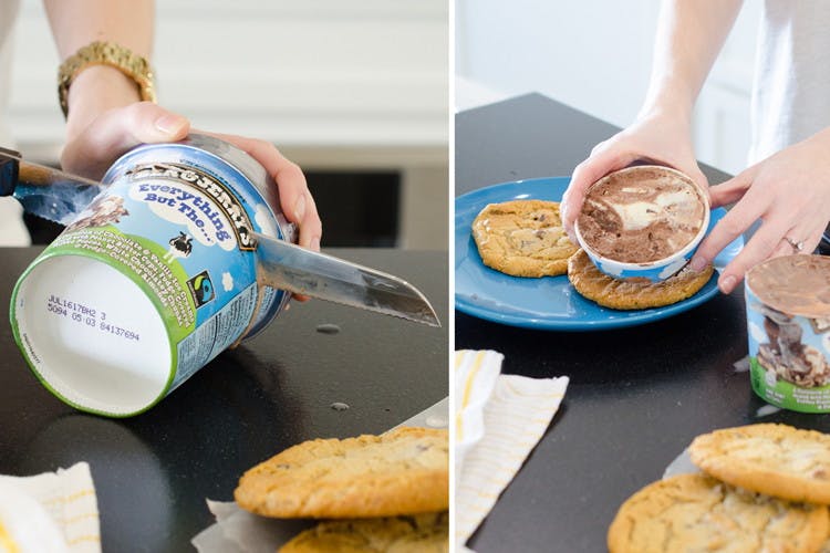 A person's hands using a knife to cut a Ben and Jerry's pint of ice cream into slices, and putting a slice onto a cookie to make an ice cream sandwich.