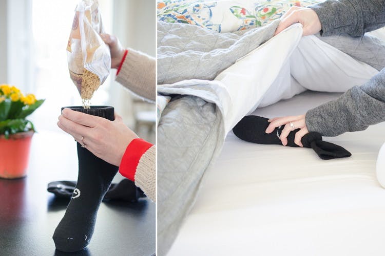 A person's hands dumping rice into a black sock to put into the freezer, and a person putting the frozen sock of rice between the bed sheets.