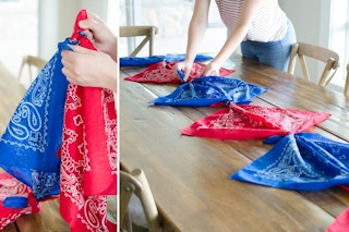 A person's hands tying red and blue bandanas together and placing them across a table like a runner.