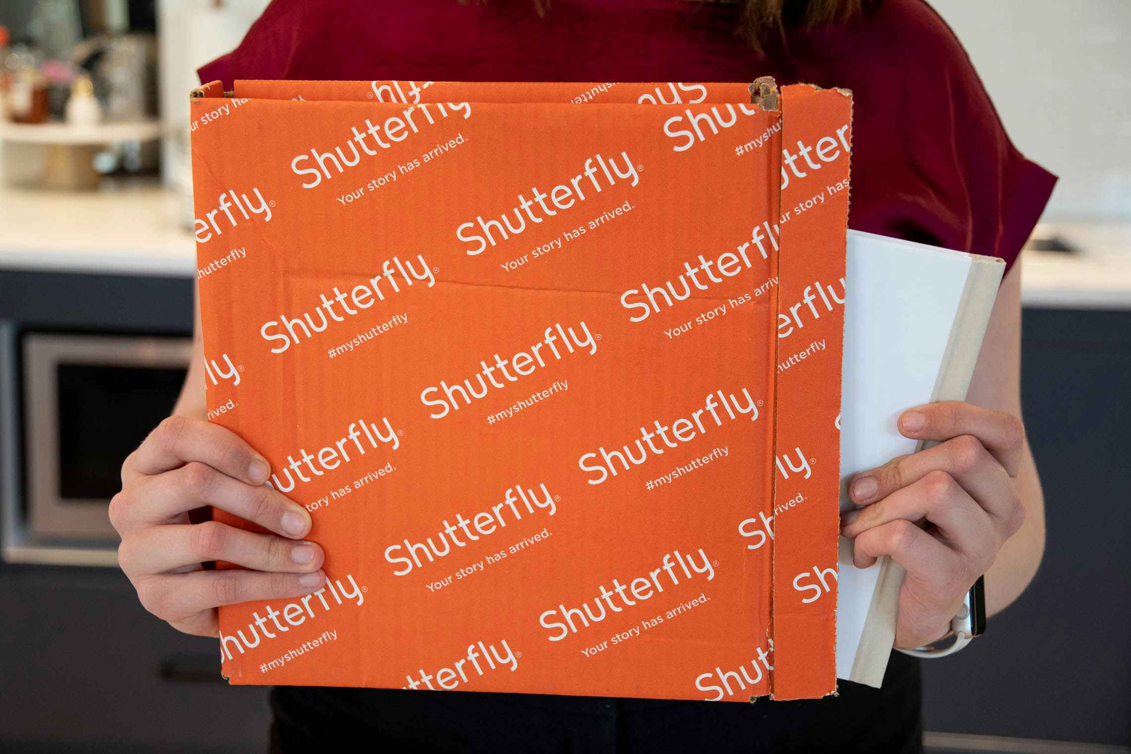 Shutterfuly box with a person pulling a book out of it.