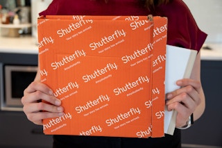 Shutterfuly box with a person pulling a book out of it.