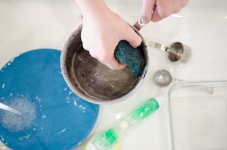 Scour and clean greasy, crusty pots and pans with used coffee grounds.