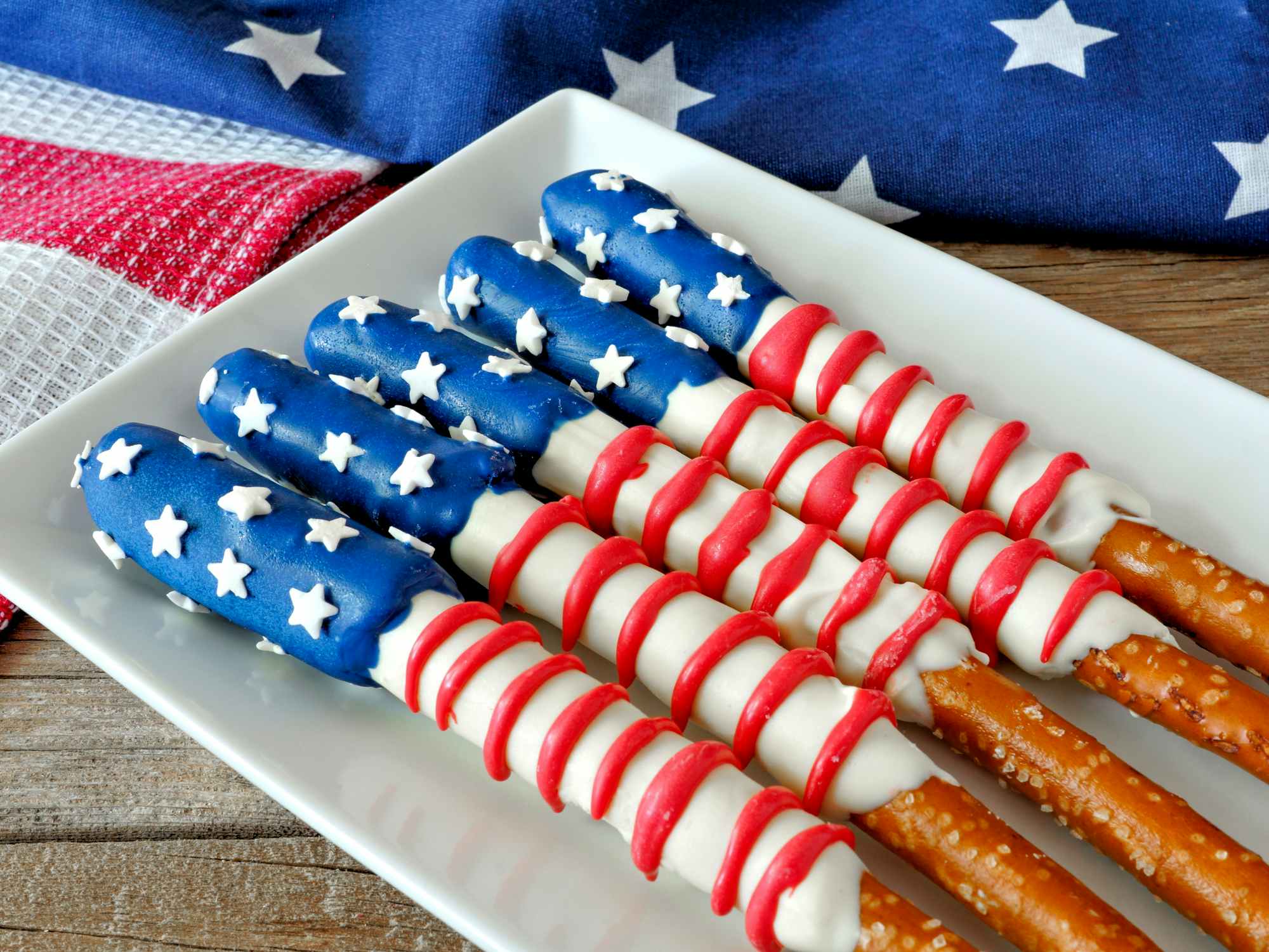Fourth of July American flag themed pretzel rods on plate with holiday decor