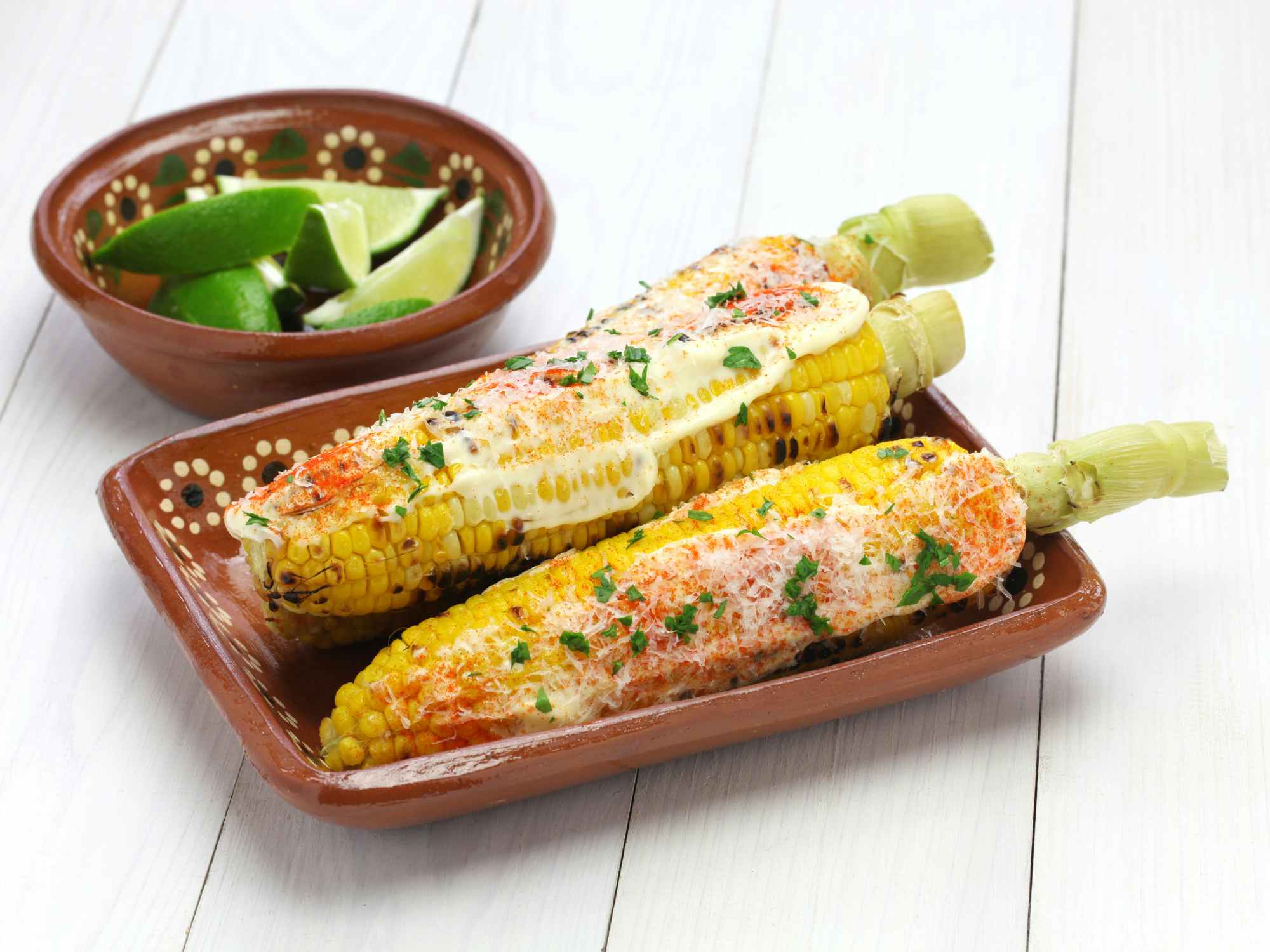 Some grilled elote corn with lime sauce