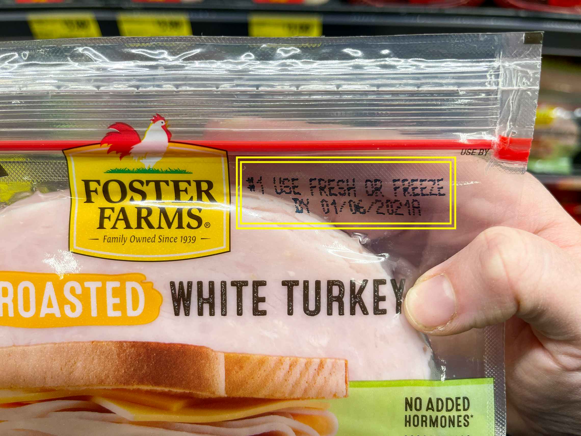 A pack of Foster Farms White Turkey sandwich meat with yellow squares around the expiration date.