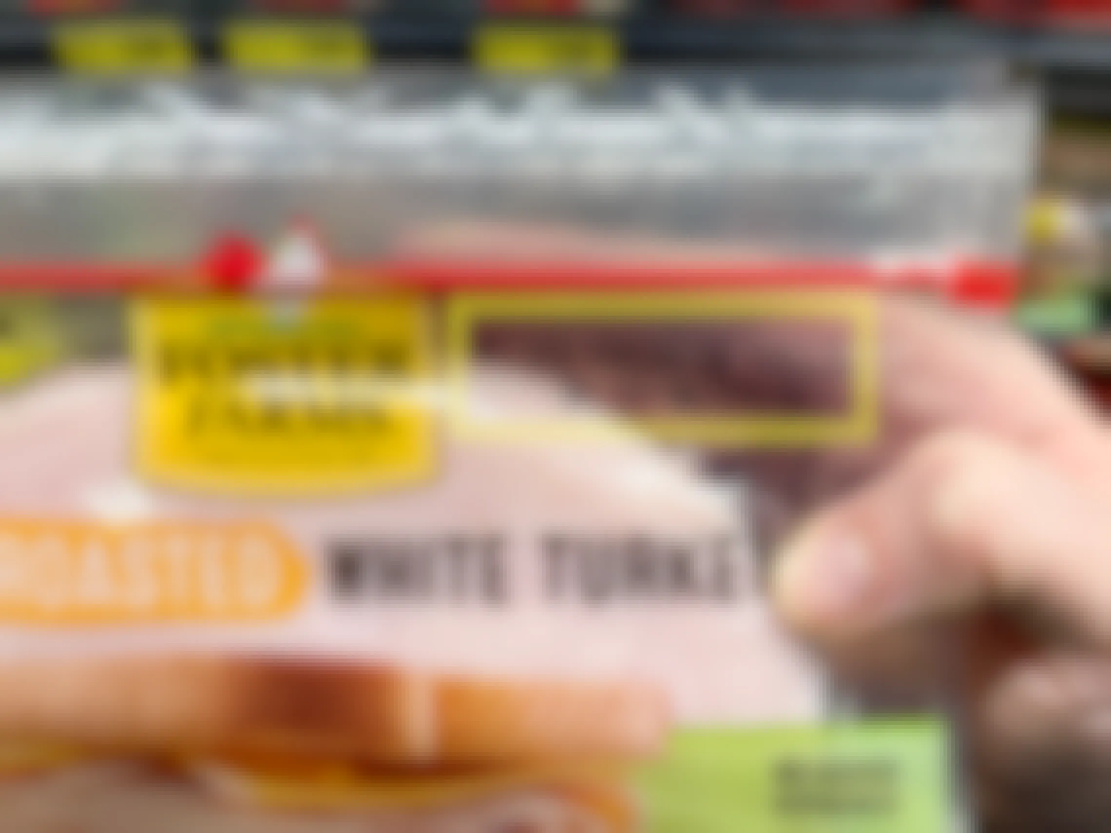 A pack of Foster Farms White Turkey sandwich meat with yellow squares around the expiration date.