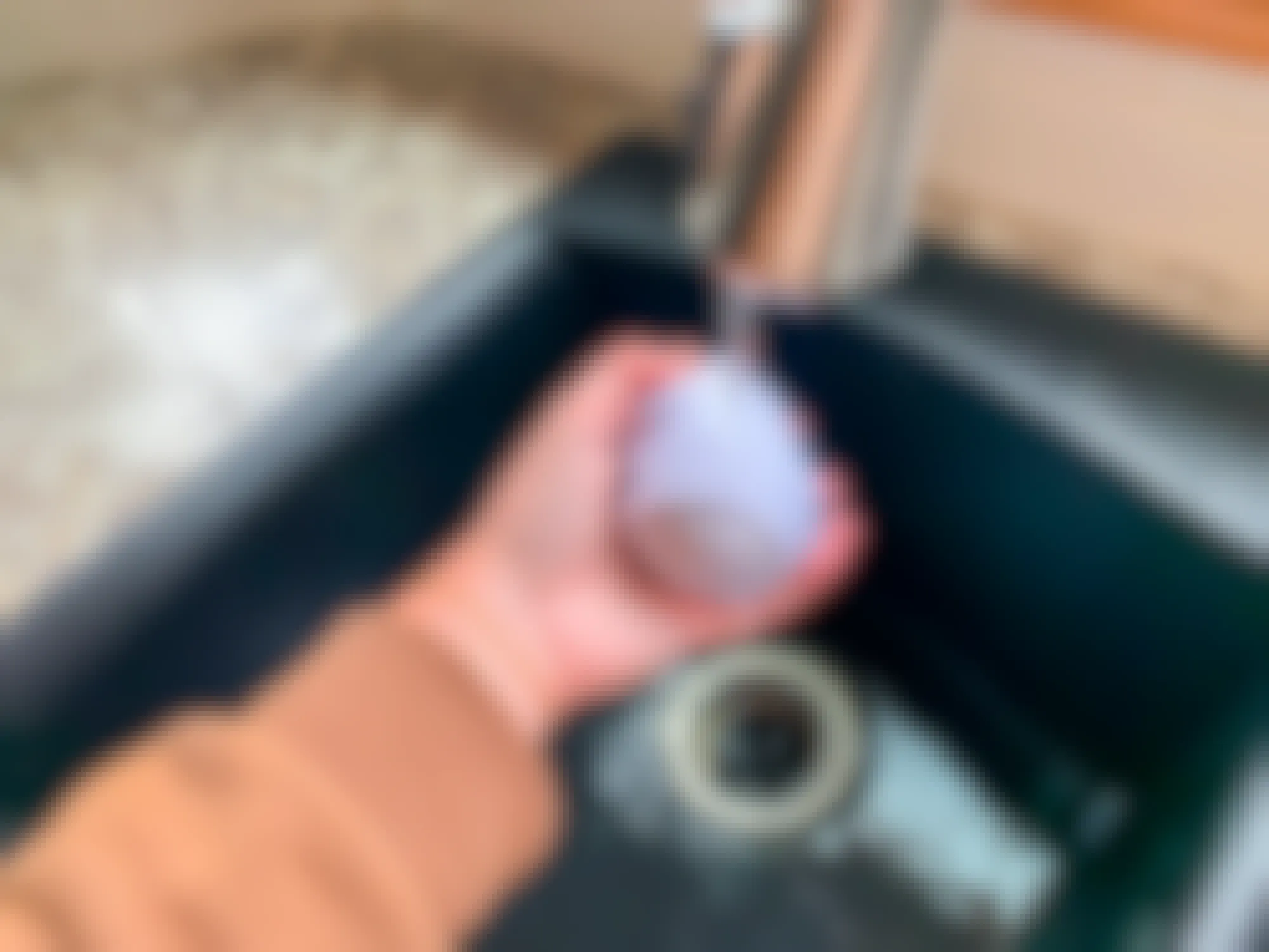 a person putting a sock ball under a water faucet
