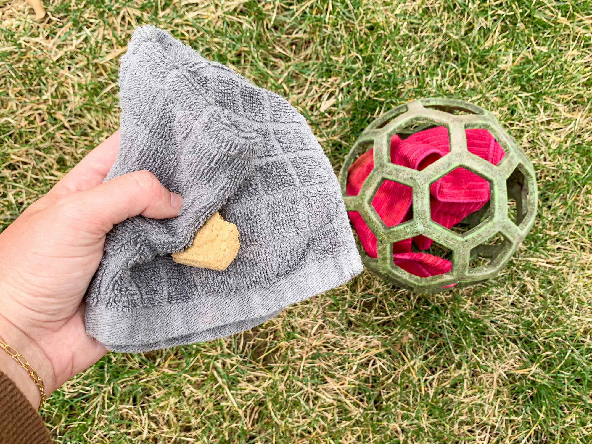 a person stuffing a ball with old wash clothes and treats