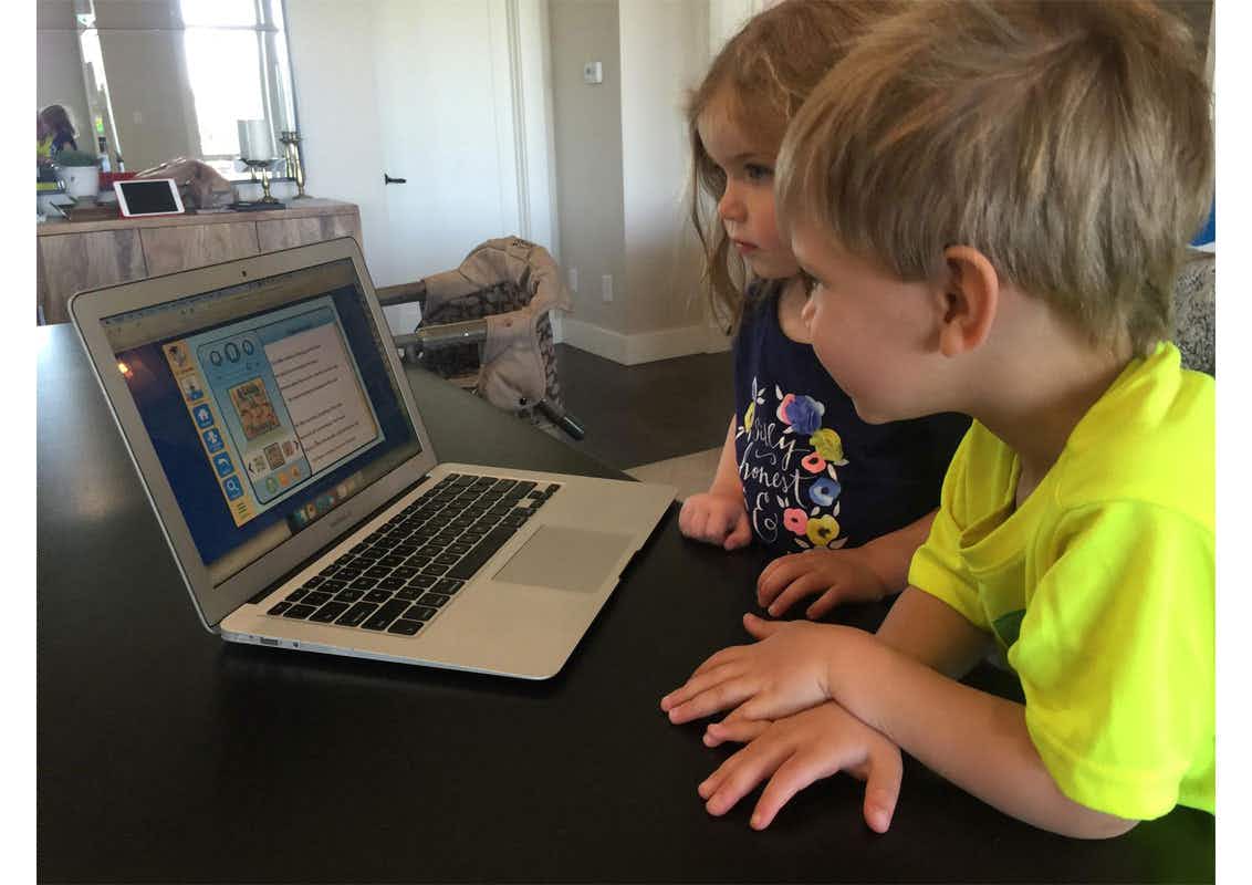 Two kids looking at a computer.