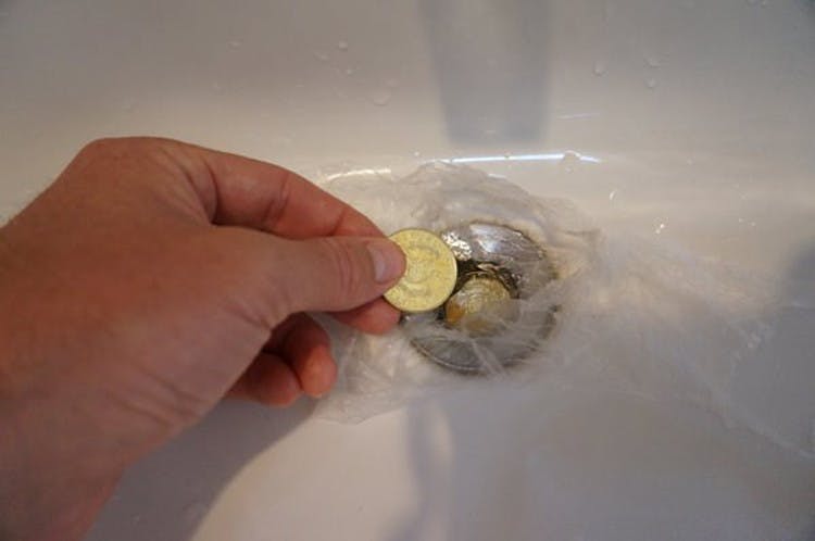 Plug up the hotel room sink with coins and plastic when it's time to do laundry.