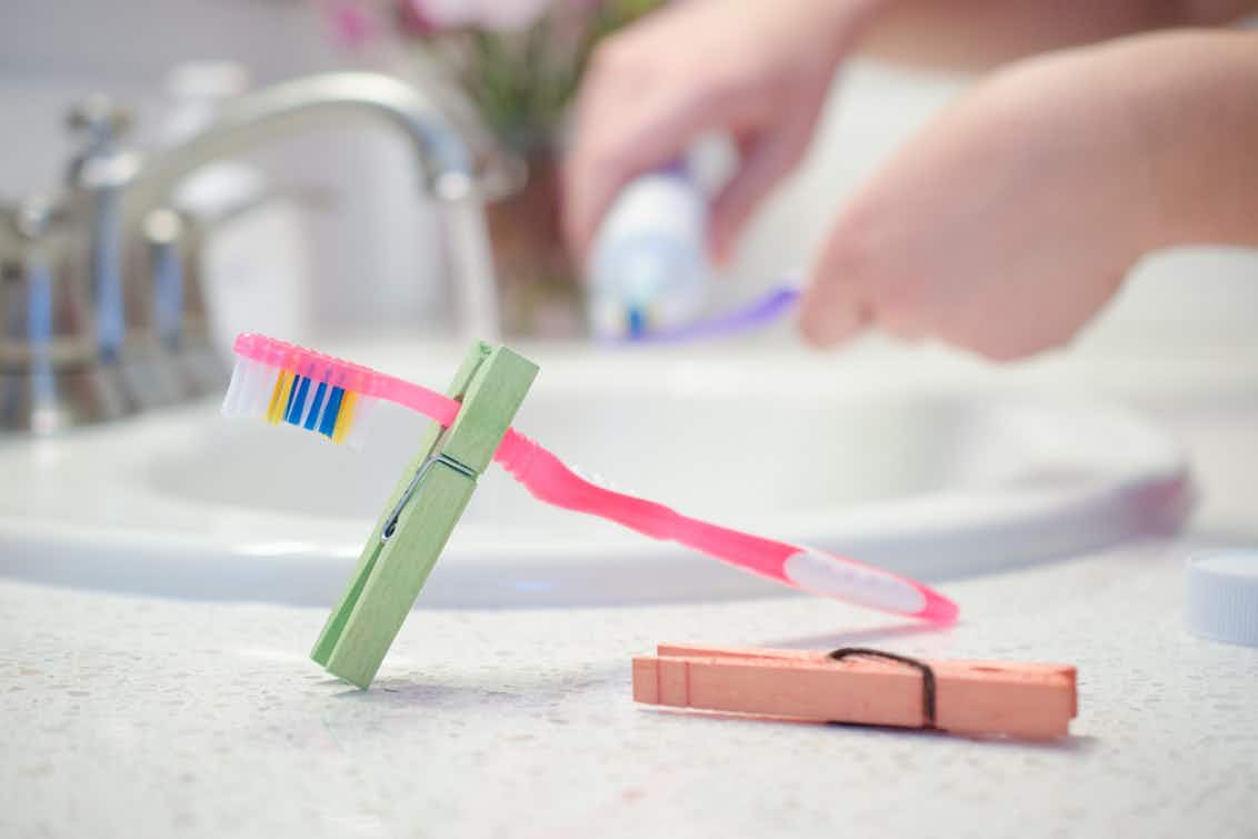 Pack clothespins and use them to keep toothbrushes off hotel bathroom counters.