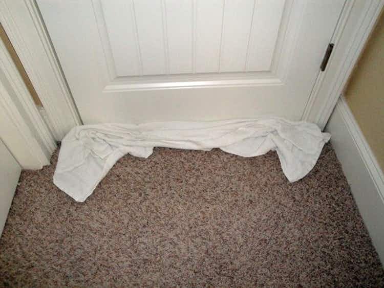 Roll up a towel and wedge it under the door to block the hall light and noise in a hotel