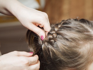 A mother braiding her child's hair
