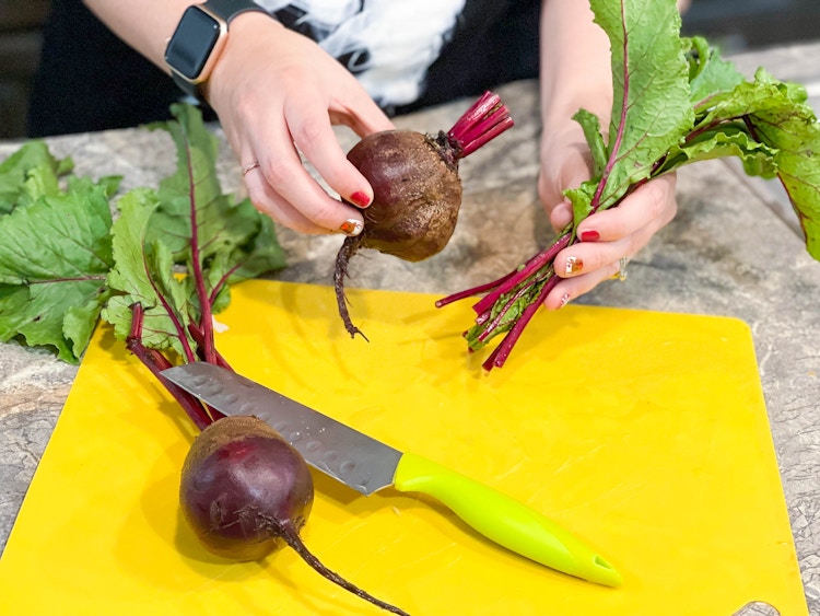 beet greens being trimmed off