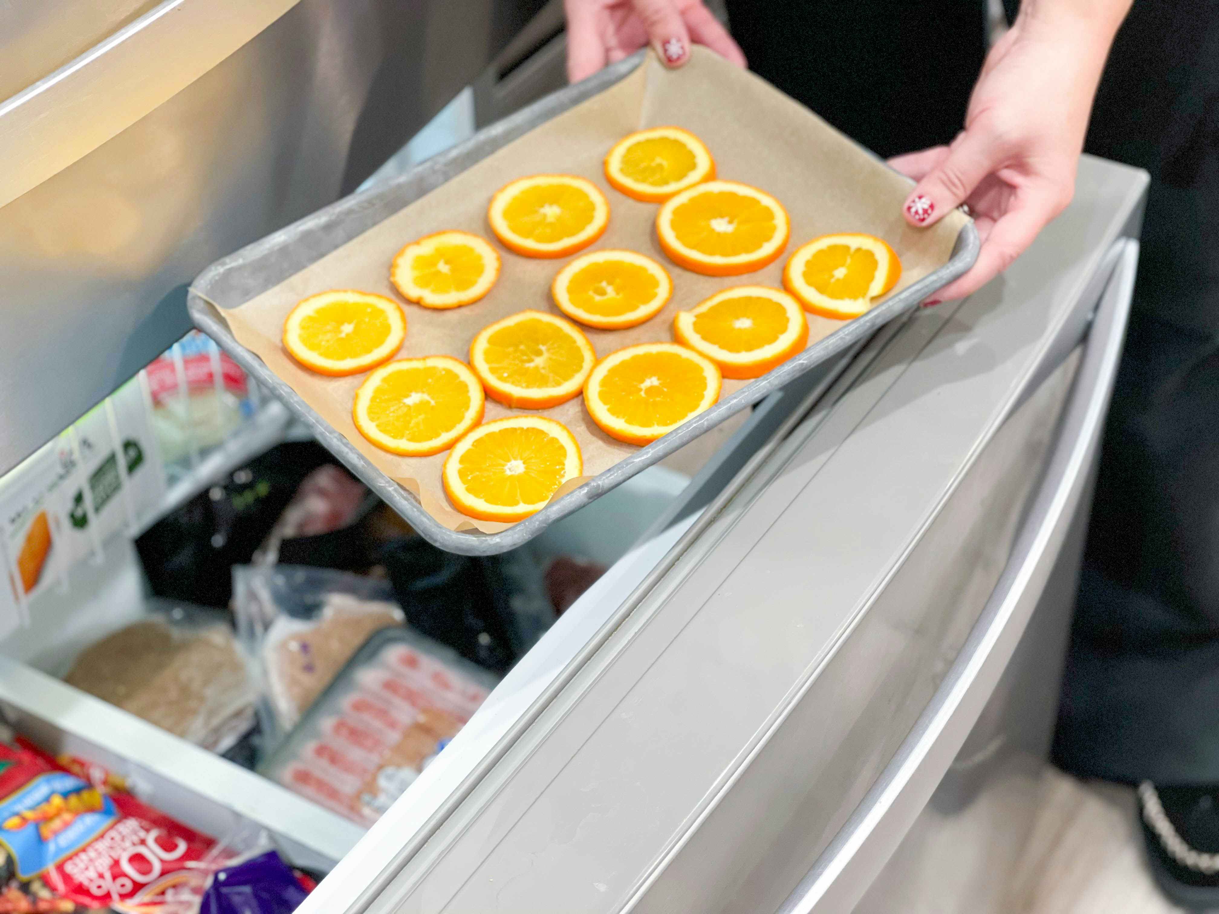 orange sliced being put in freezer