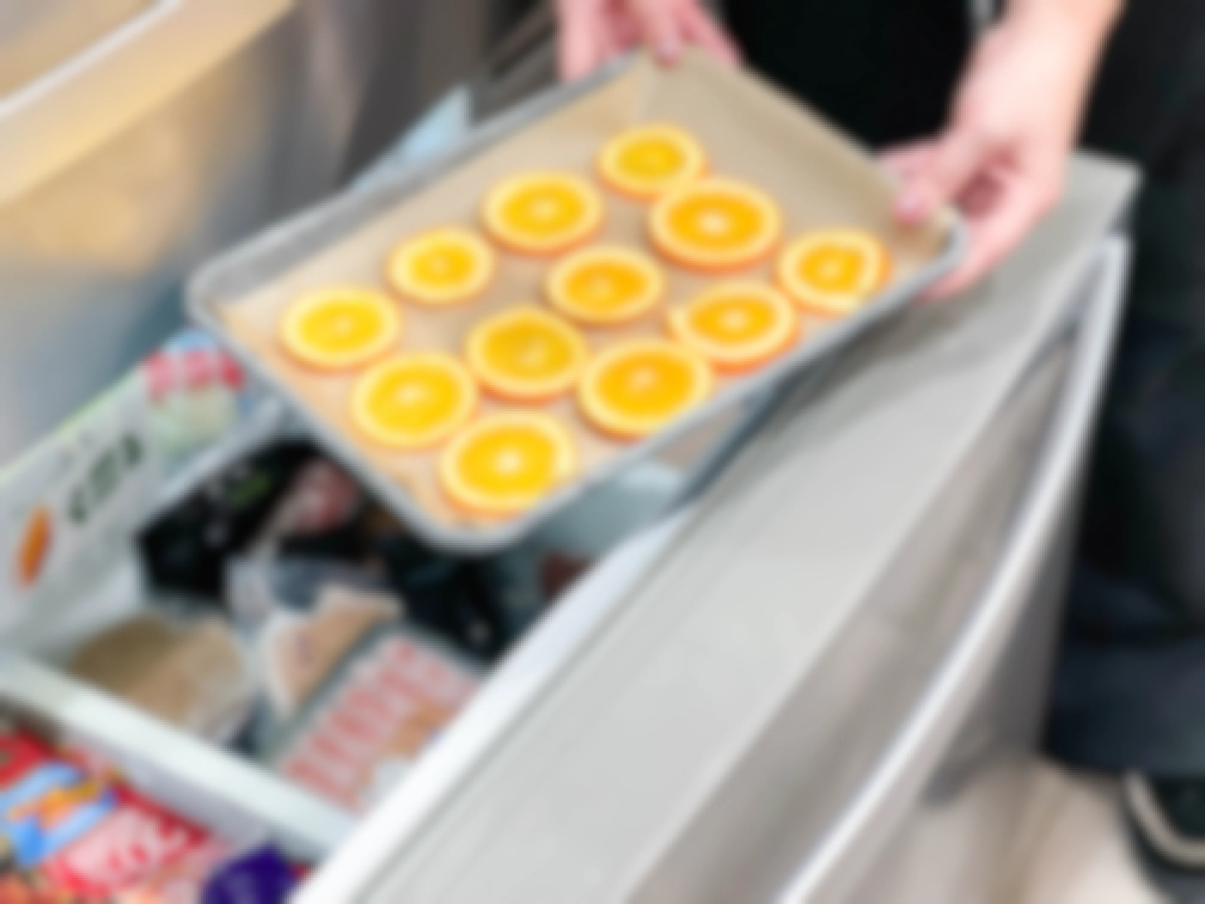 orange sliced being put in freezer