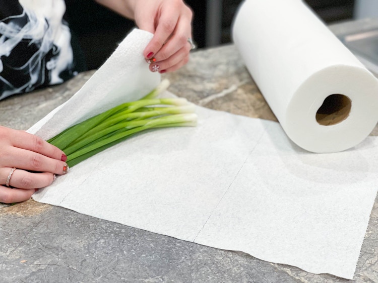 green onions being wrapped in paper towels