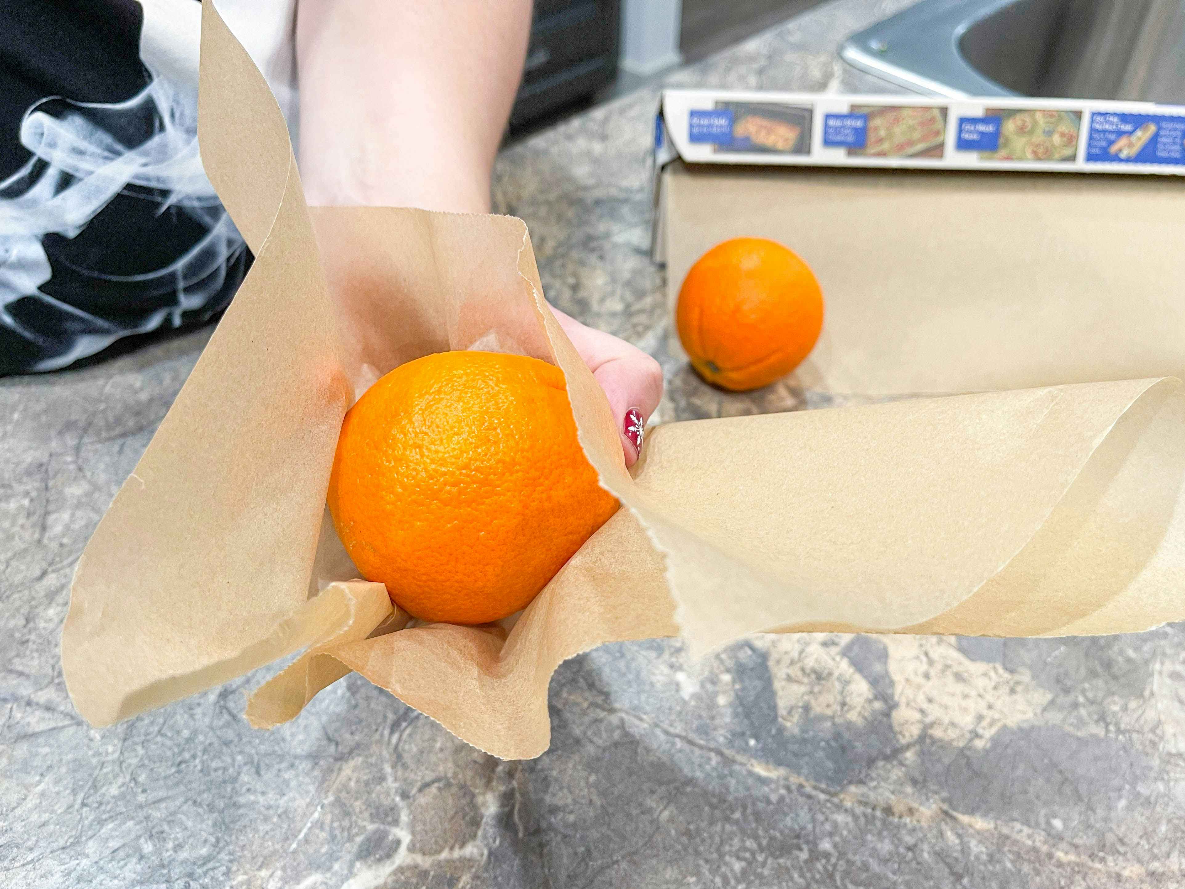 oranges being wrapped in parchment paper