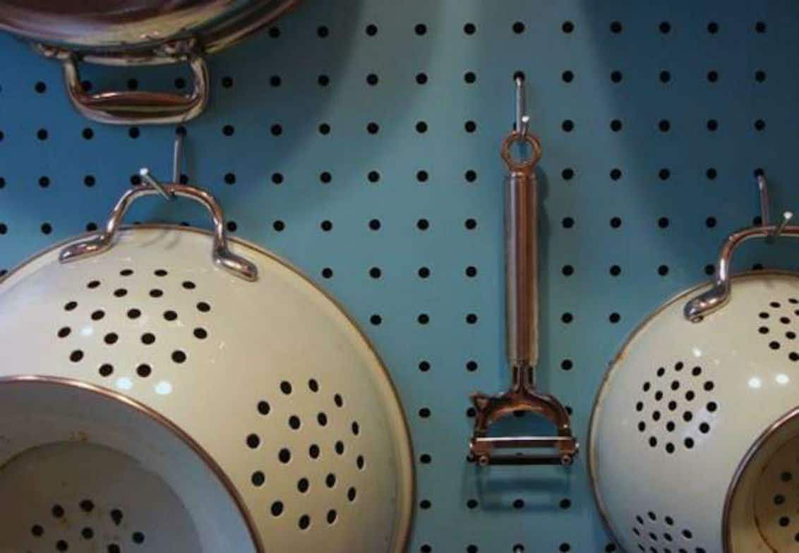 Hang kitchen items from a pegboard.