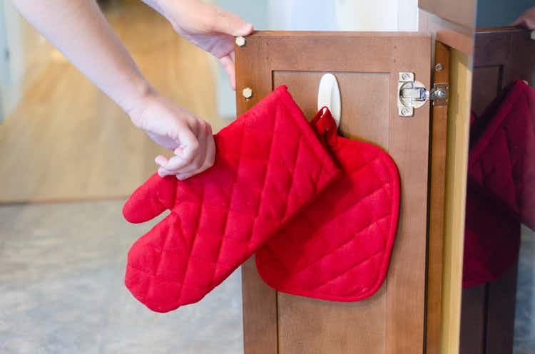 Store oven mitts and hot pads inside cabinets with adhesive hooks.